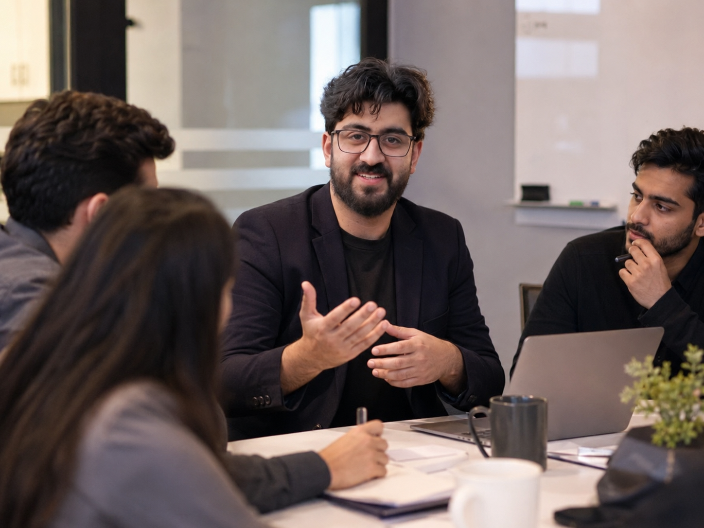 Abdullah working with his team around a table